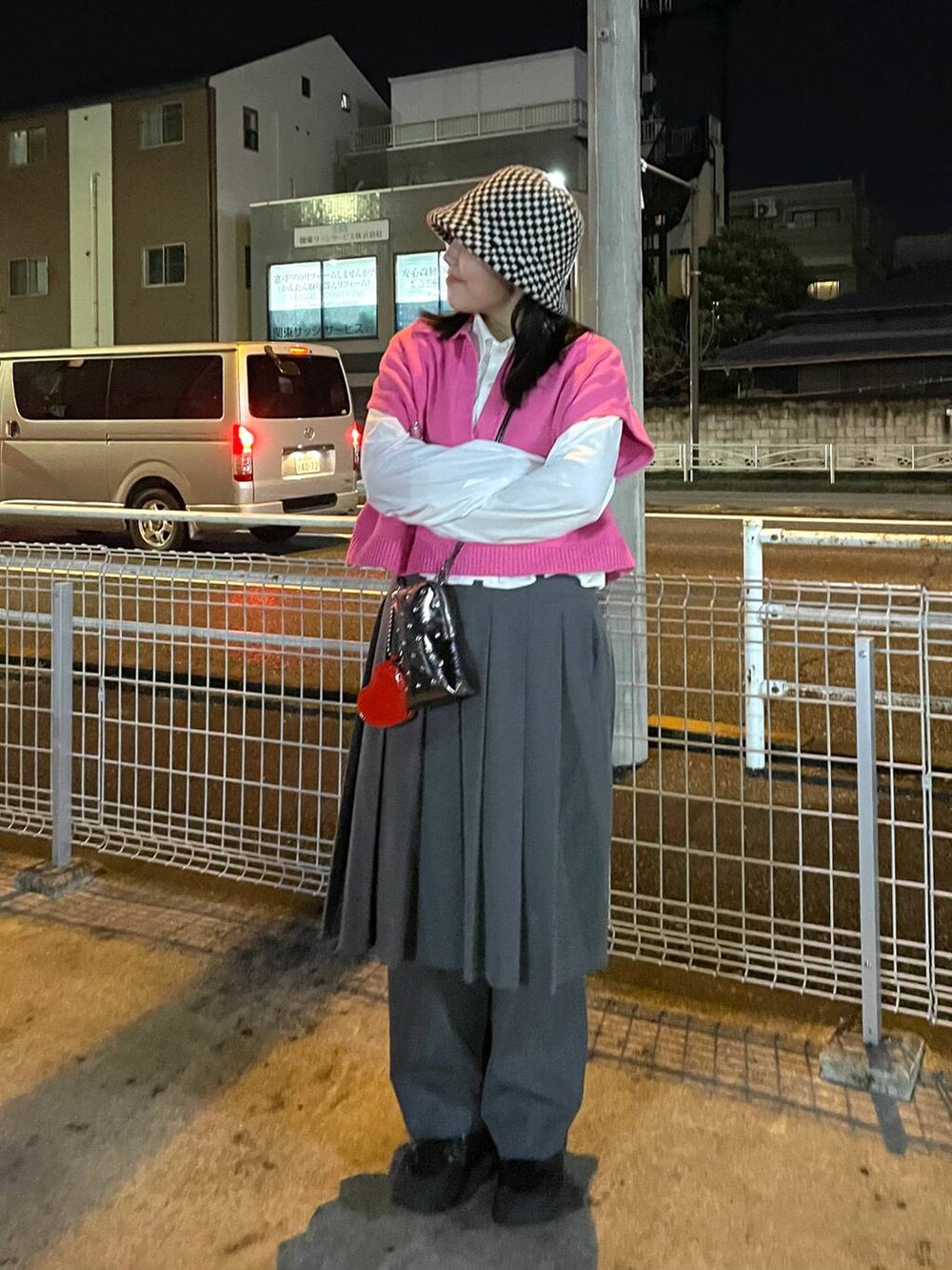 ピンク系のベスト、グレー系のスカートを着用したレディースの冬コーディネートの2枚目の写真