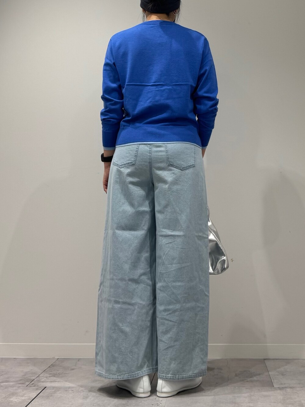 シルバー系のショルダーバッグ、ブルー系のカーディガン/ボレロ、ブルー系のデニムパンツを着用したレディースの冬コーディネートの3枚目の写真