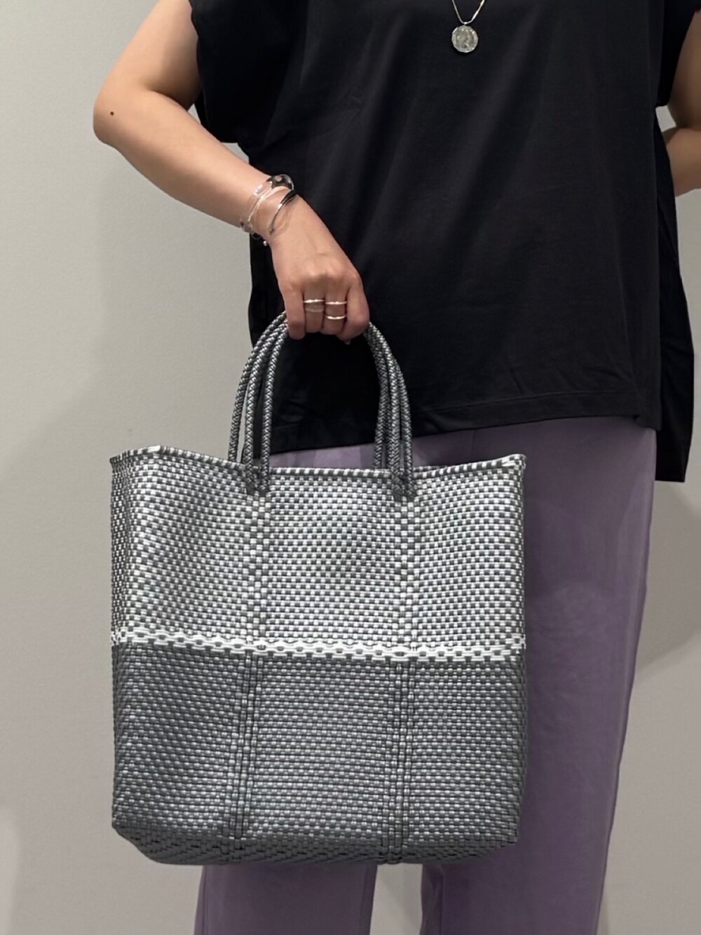 グレー系のTシャツ/カットソー、シルバー系のかごバッグ、ブラック系のサンダルを着用したレディースの夏コーディネートの10枚目の写真