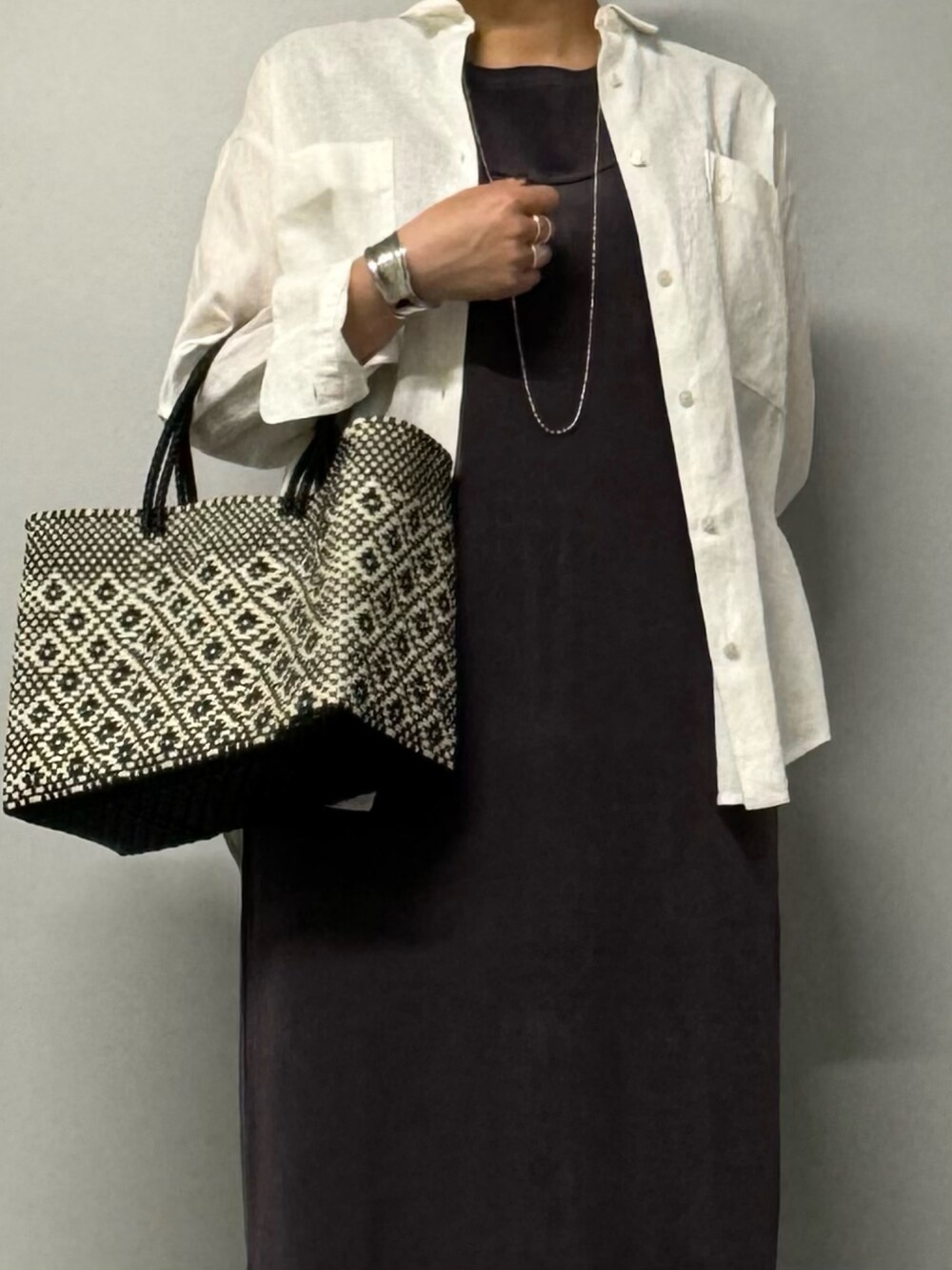 グレー系のワンピース、ホワイト系のシャツ/ブラウス、ブラック系のサンダルを着用したレディースの夏コーディネートの3枚目の写真