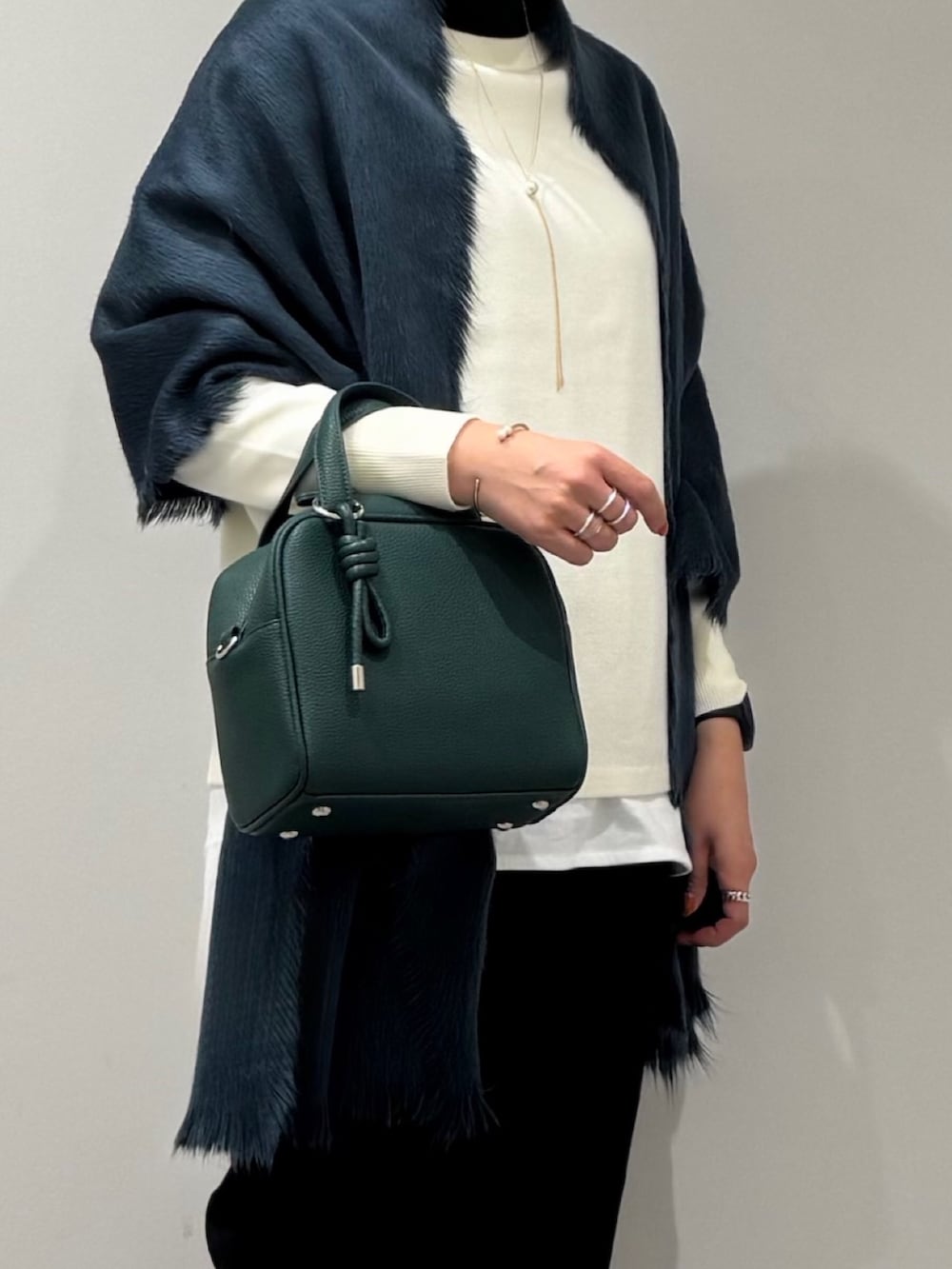 グリーン系のボストンバッグ、ブラック系のその他パンツ、ブラック系のローファーを着用したレディースの冬コーディネートの8枚目の写真