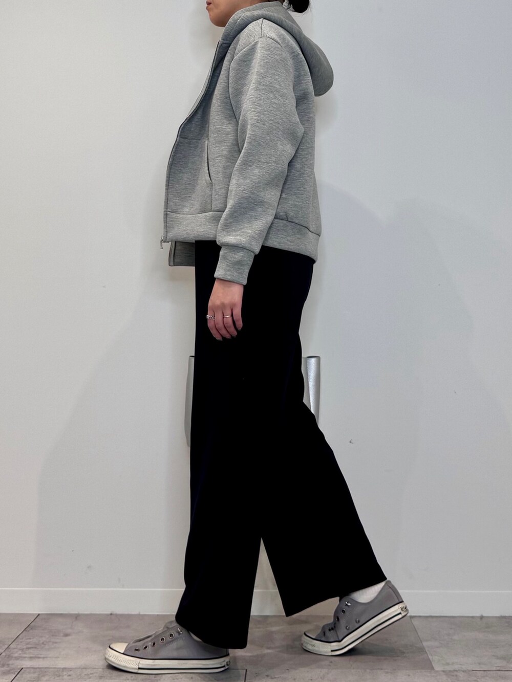 シルバー系のトートバッグ、ブラック系のサロペット/オーバーオール、グレー系のパーカーを着用したレディースの冬コーディネートの5枚目の写真