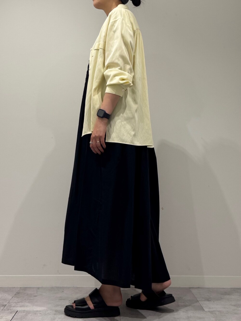 ブラウン系のトートバッグ、ブラック系のワンピース、イエロー系のシャツ/ブラウスを着用したレディースの秋コーディネートの5枚目の写真