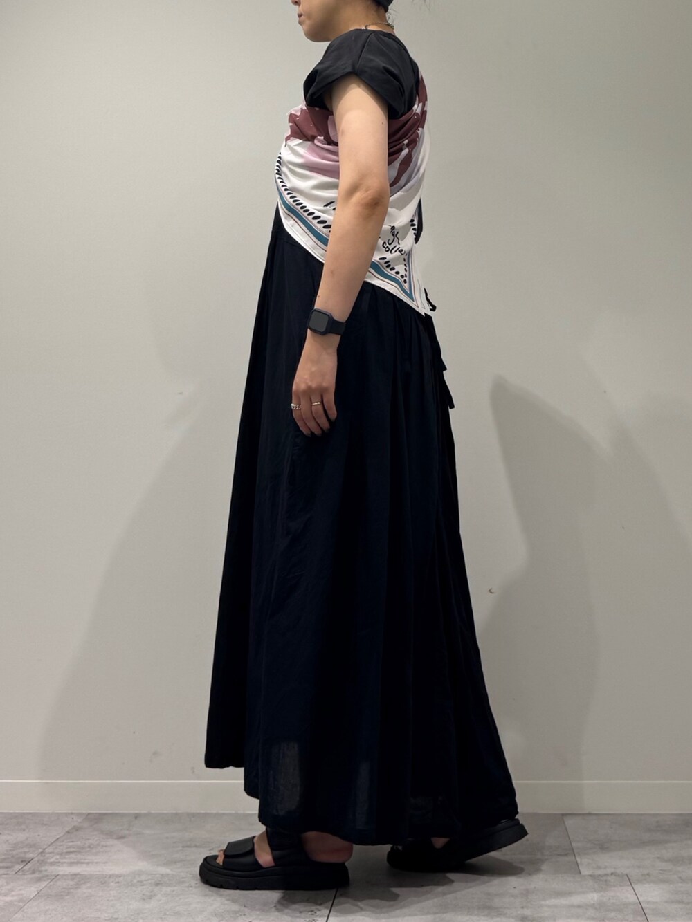 ブラック系のワンピース、シルバー系のかごバッグ、ブラック系のサンダルを着用したレディースの夏コーディネートの6枚目の写真