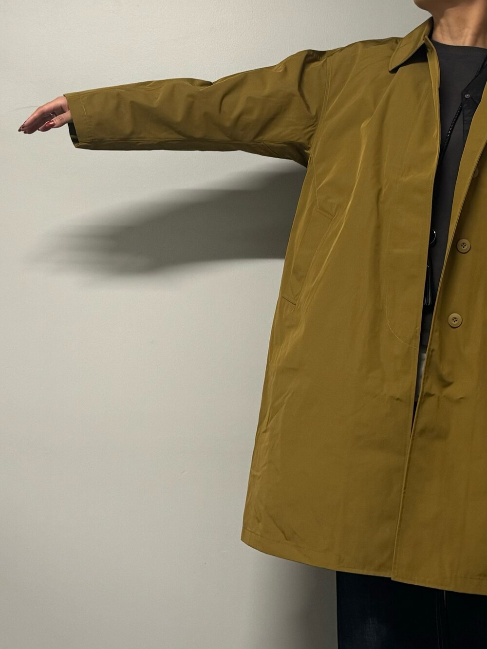 ベージュ系のダウンジャケット/コート、ブラック系のボストンバッグ、ブルー系のデニムパンツを着用したレディースの秋コーディネートの7枚目の写真