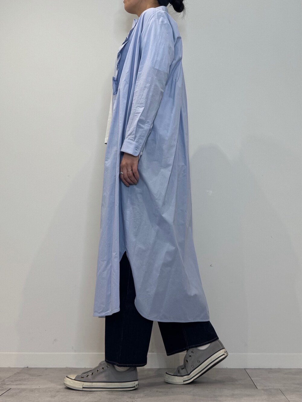 ブルー系のシャツワンピース、シルバー系のかごバッグ、ブルー系のデニムパンツを着用したレディースの春コーディネートの6枚目の写真