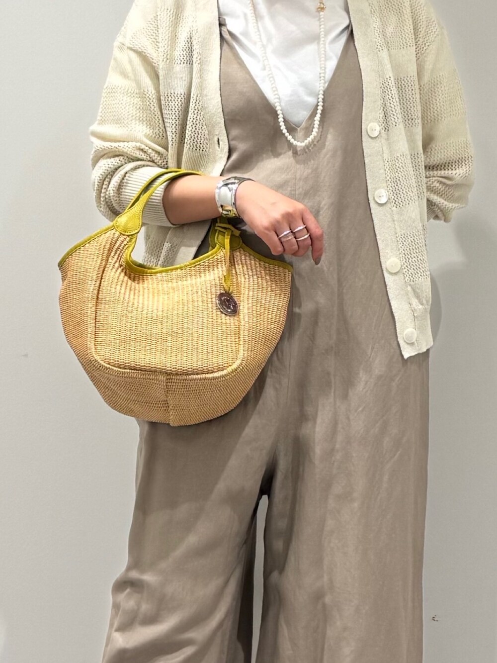 ベージュ系のサロペット/オーバーオール、ホワイト系のカーディガン/ボレロ、ベージュ系のかごバッグを着用したレディースの春コーディネートの10枚目の写真