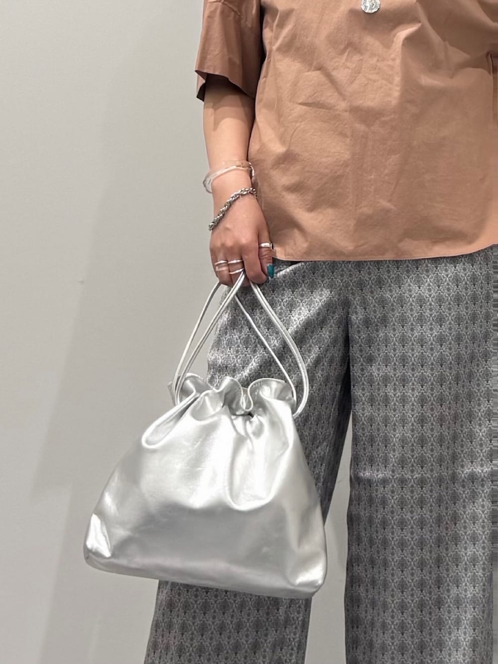 シルバー系のショルダーバッグ、ピンク系のシャツ/ブラウス、ベージュ系のその他パンツを着用したレディースの夏コーディネートの6枚目の写真