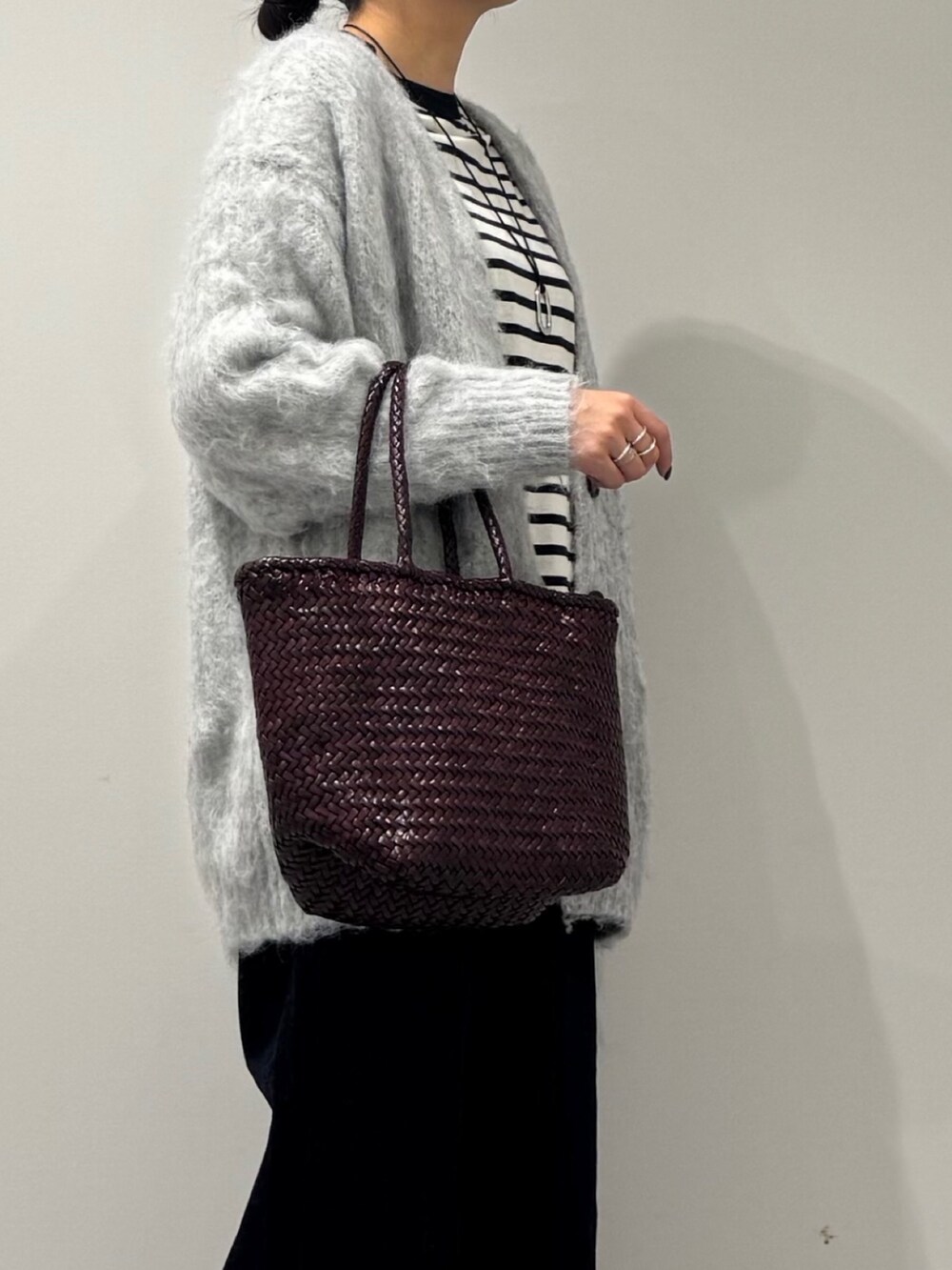 パープル系のトートバッグ、ブルー系のデニムパンツ、ブラック系のTシャツ/カットソーを着用したレディースの冬コーディネートの8枚目の写真