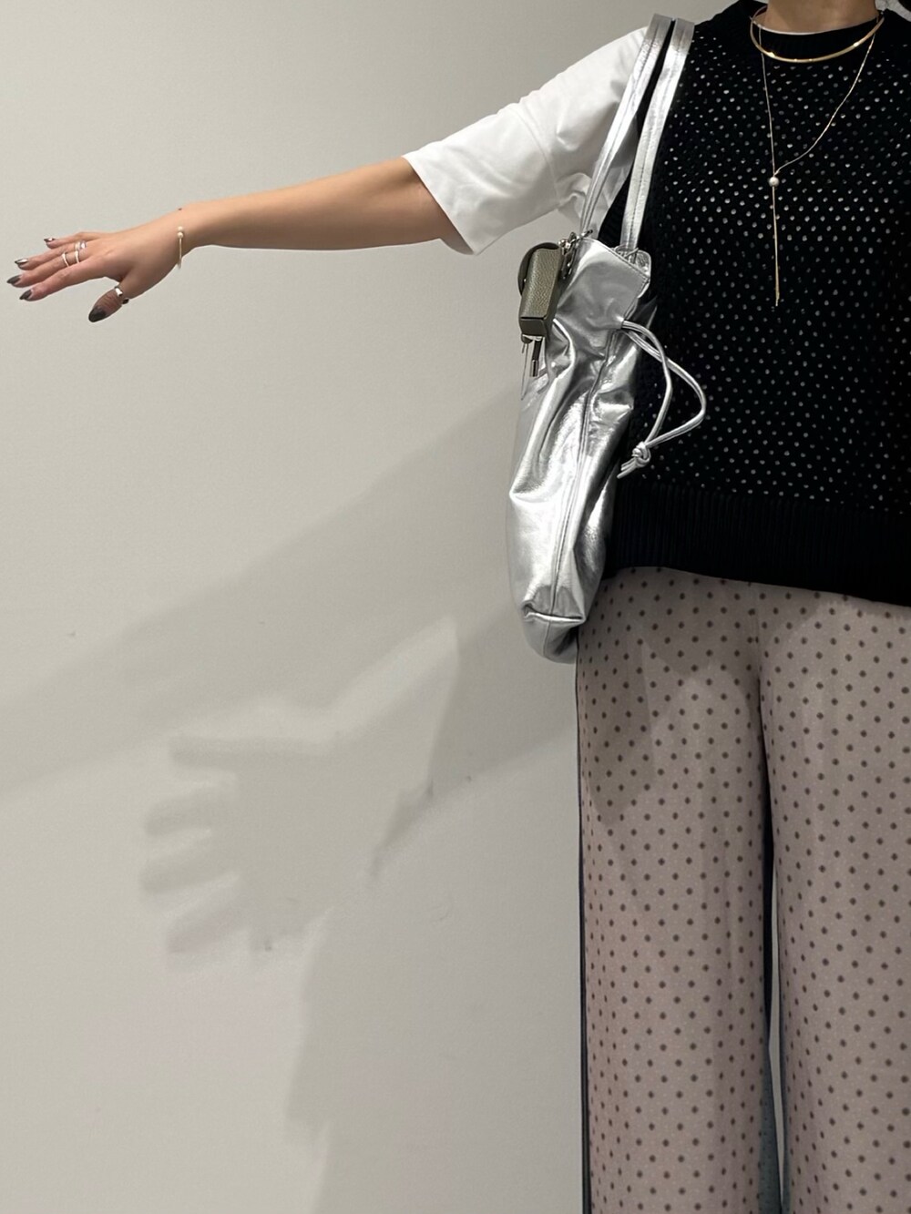 ブラック系のベスト、ベージュ系のその他パンツ、ブラック系のローファーを着用したレディースの春コーディネートの6枚目の写真