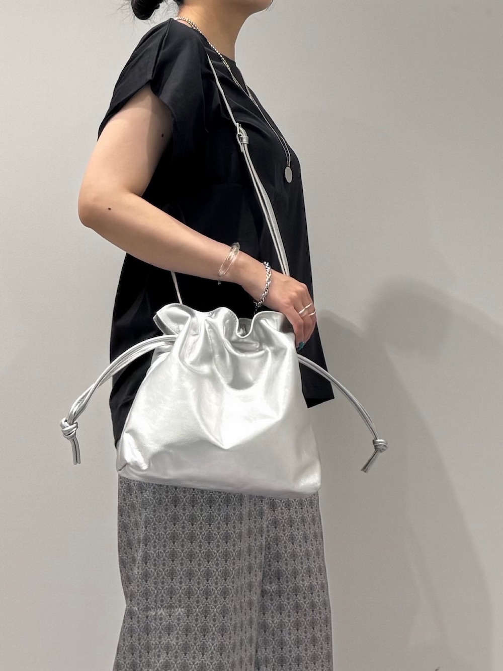 シルバー系のショルダーバッグ、グレー系のTシャツ/カットソー、ベージュ系のその他パンツを着用したレディースの秋コーディネートの7枚目の写真