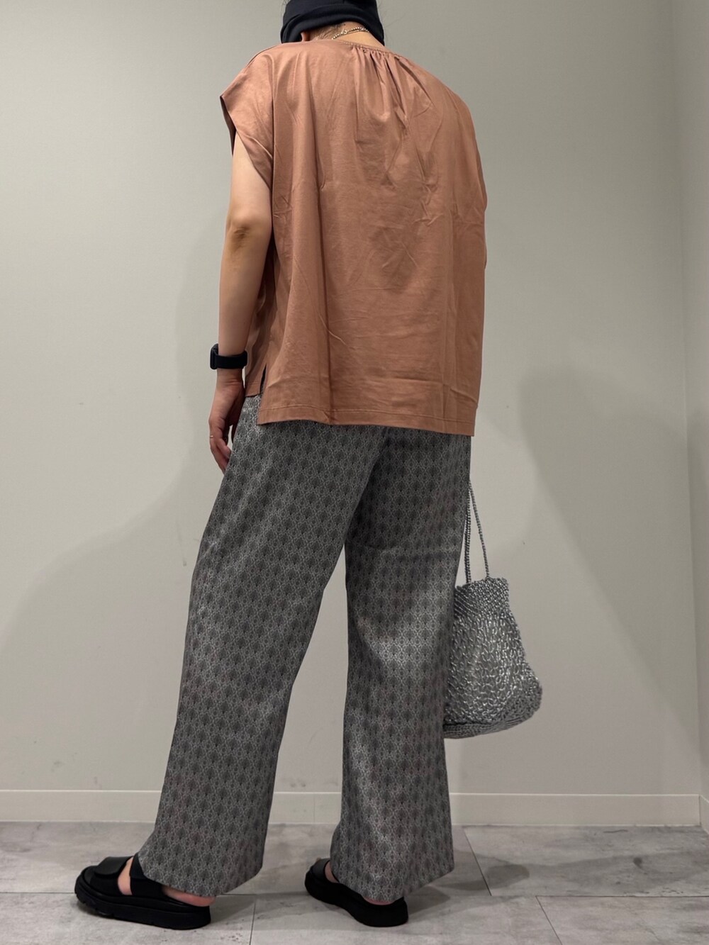 ピンク系のTシャツ/カットソー、シルバー系のかごバッグ、ベージュ系のその他パンツを着用したレディースの夏コーディネートの5枚目の写真