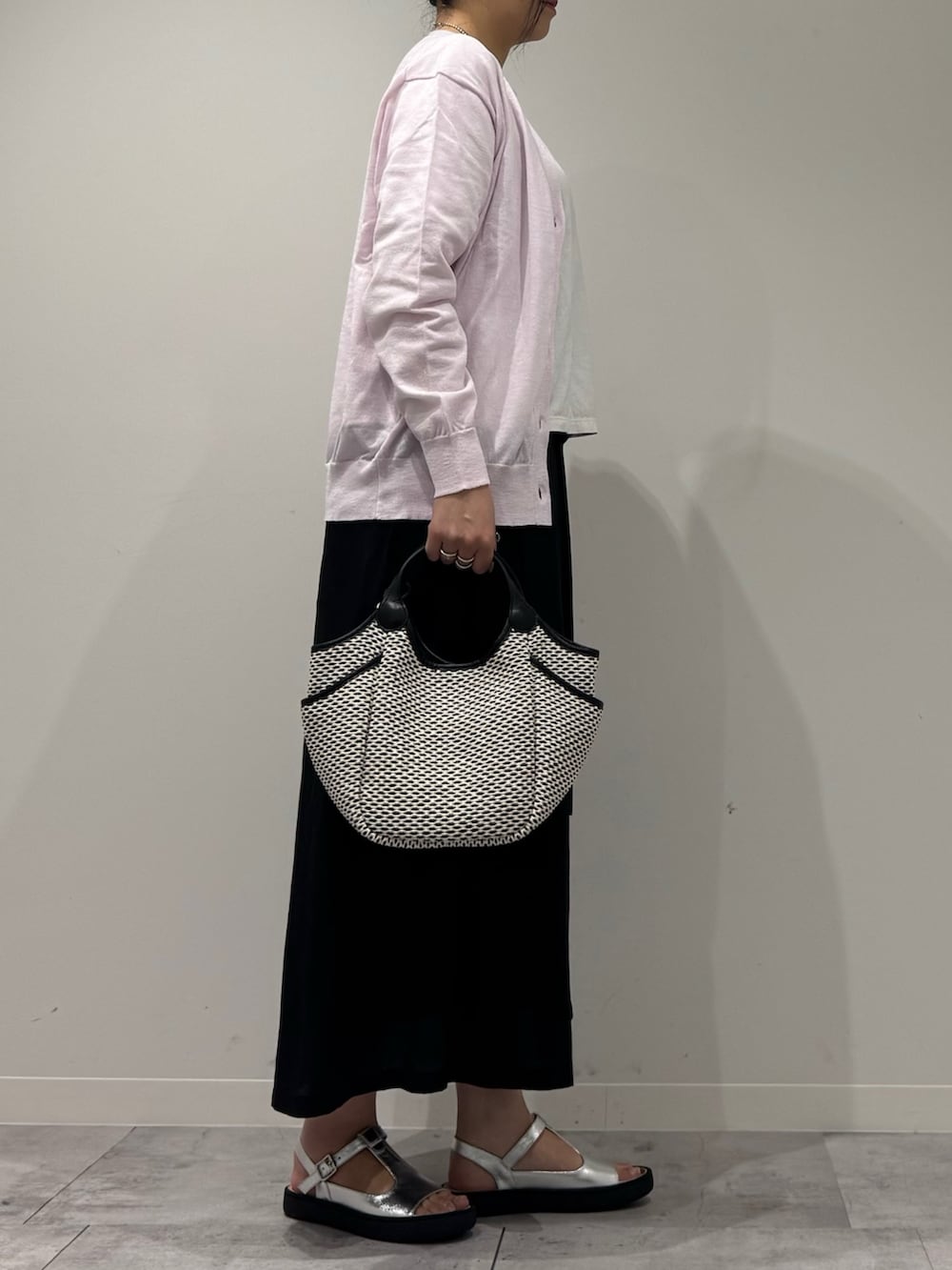 ブラック系のかごバッグ、ピンク系のカーディガン/ボレロ、ホワイト系のTシャツ/カットソーを着用したレディースの春コーディネートの2枚目の写真