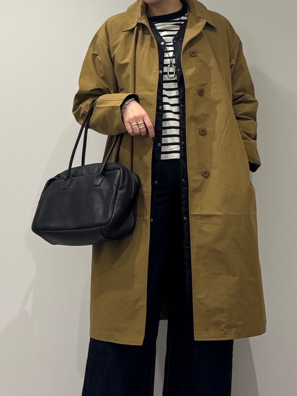 ブラック系のボストンバッグ、ベージュ系のダウンジャケット/コート、ブルー系のデニムパンツを着用したレディースの冬コーディネートの9枚目の写真