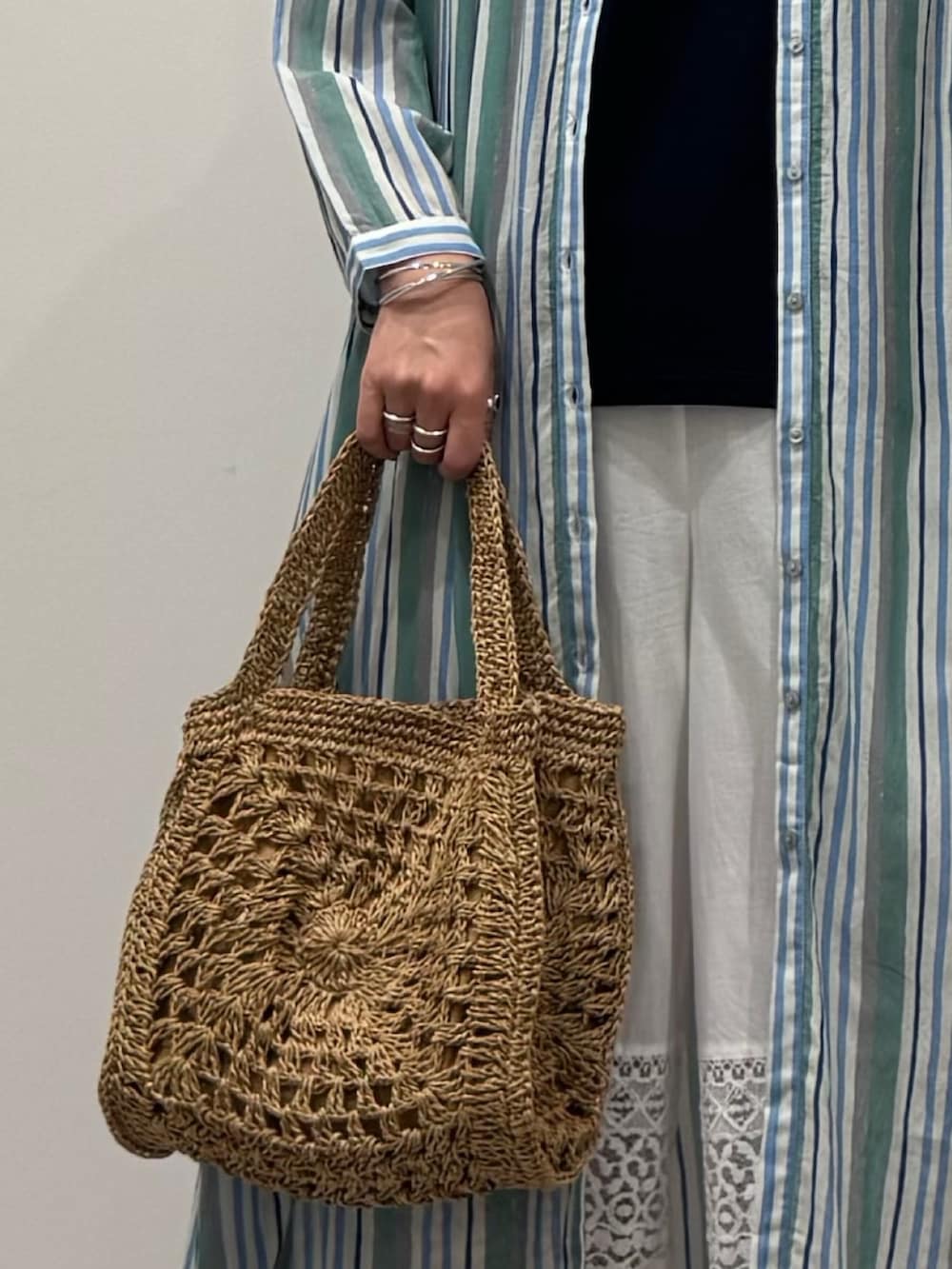 ベージュ系のかごバッグ、ホワイト系のその他パンツ、ブラック系のサンダルを着用したレディースの夏コーディネートの7枚目の写真