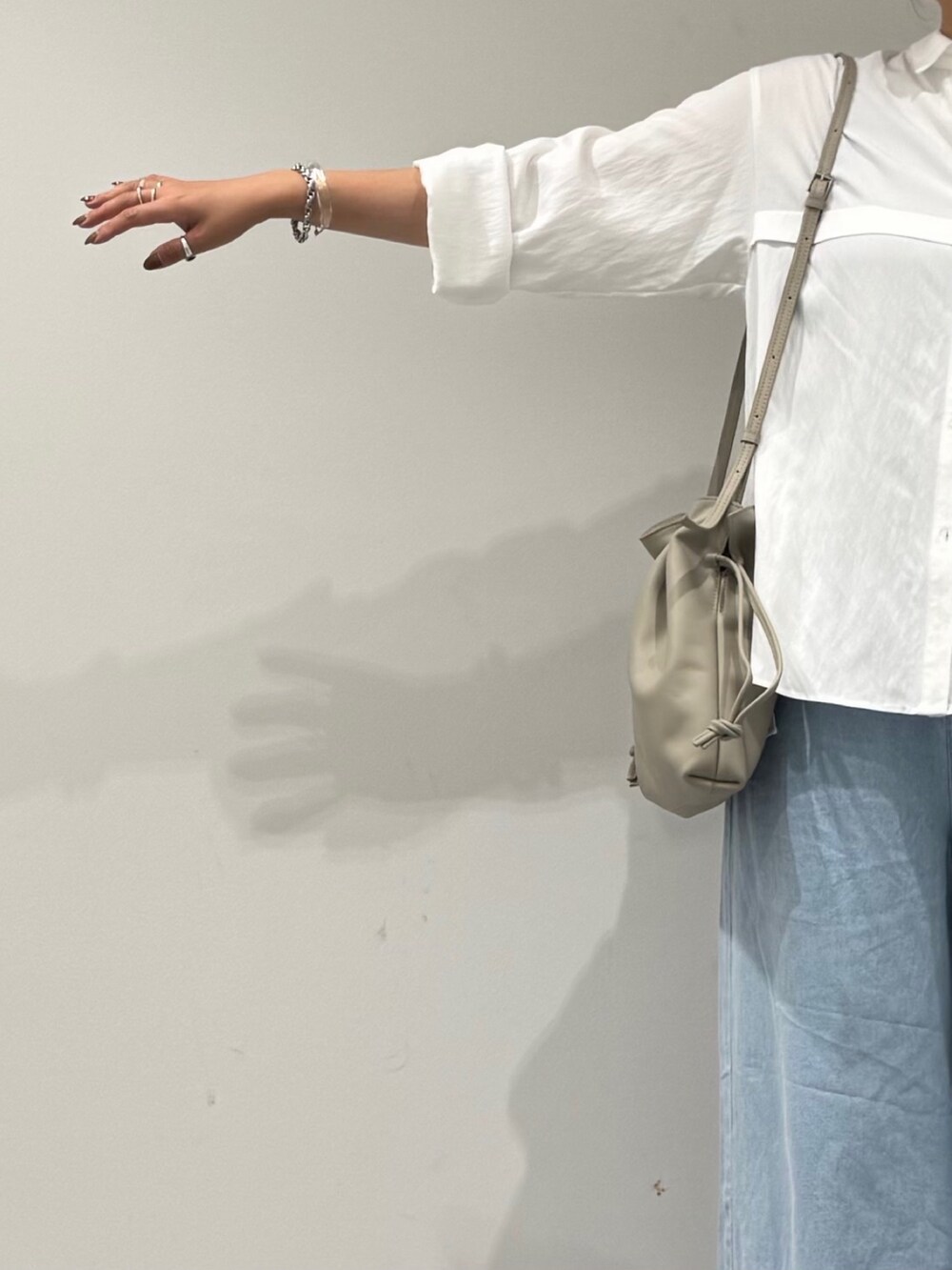 ベージュ系のショルダーバッグ、ブルー系のデニムパンツ、ブラック系のサンダルを着用したレディースの秋コーディネートの7枚目の写真