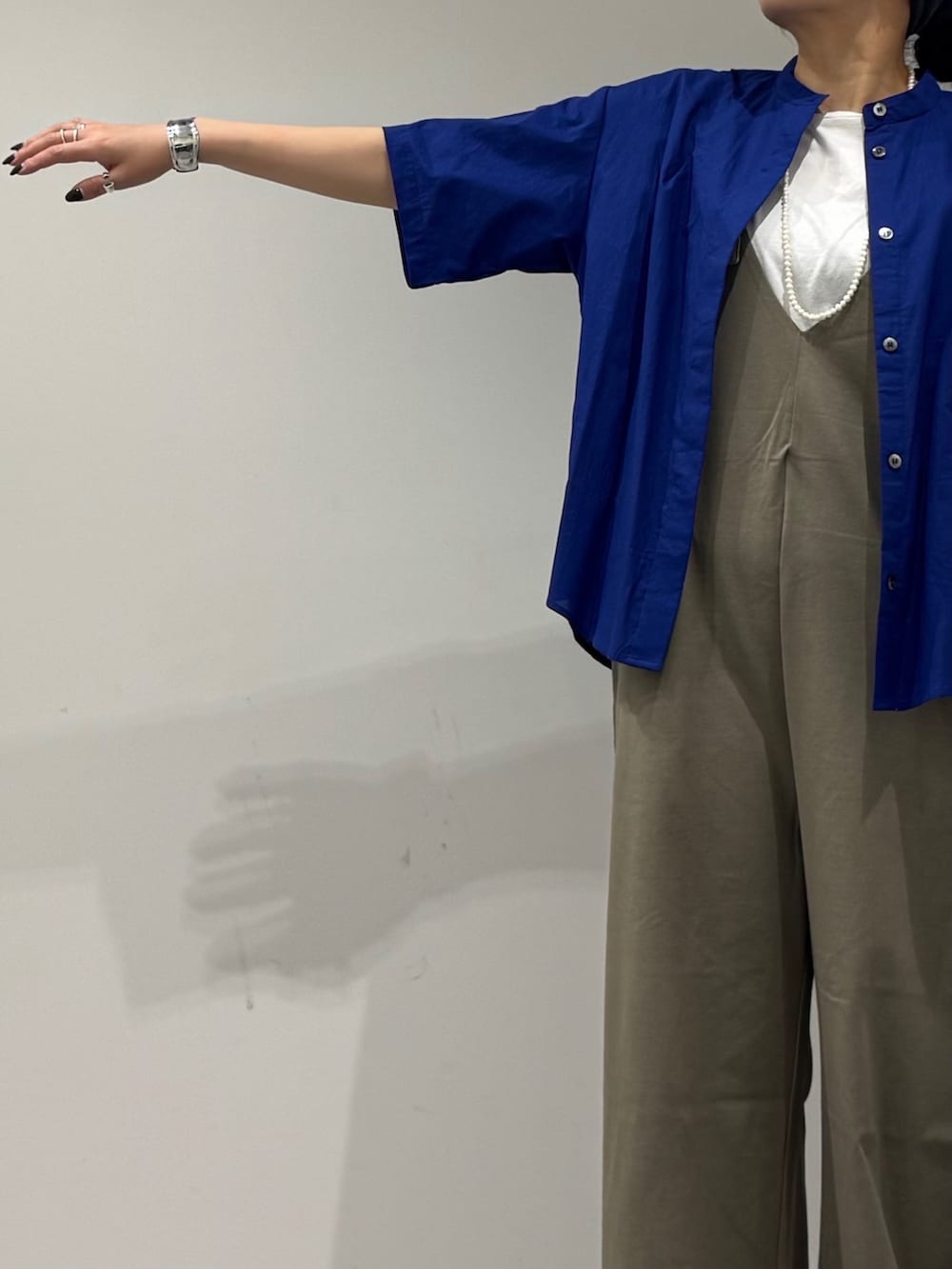 シルバー系のかごバッグ、グリーン系のサロペット/オーバーオール、ブルー系のシャツ/ブラウスを着用したレディースの夏コーディネートの5枚目の写真