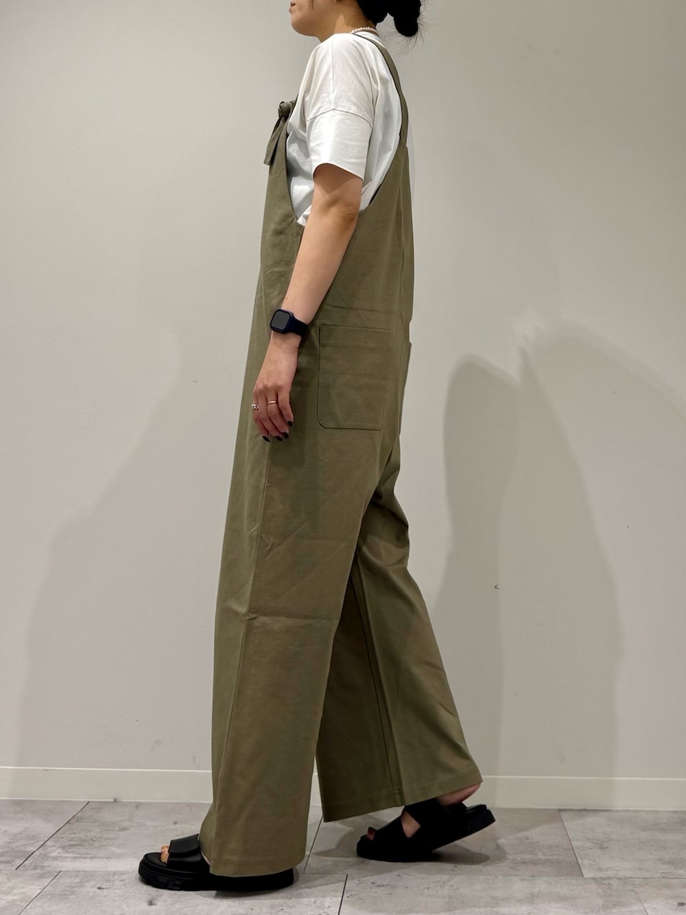 シルバー系のかごバッグ、ブラック系のサンダル、ホワイト系のTシャツ/カットソーを着用したレディースの夏コーディネートの6枚目の写真