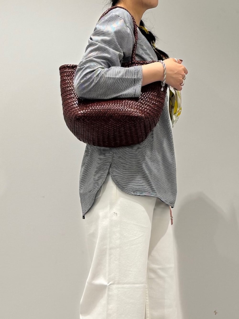 ブラウン系のトートバッグ、ホワイト系のデニムパンツ、ブラック系のローファーを着用したレディースの秋コーディネートの8枚目の写真