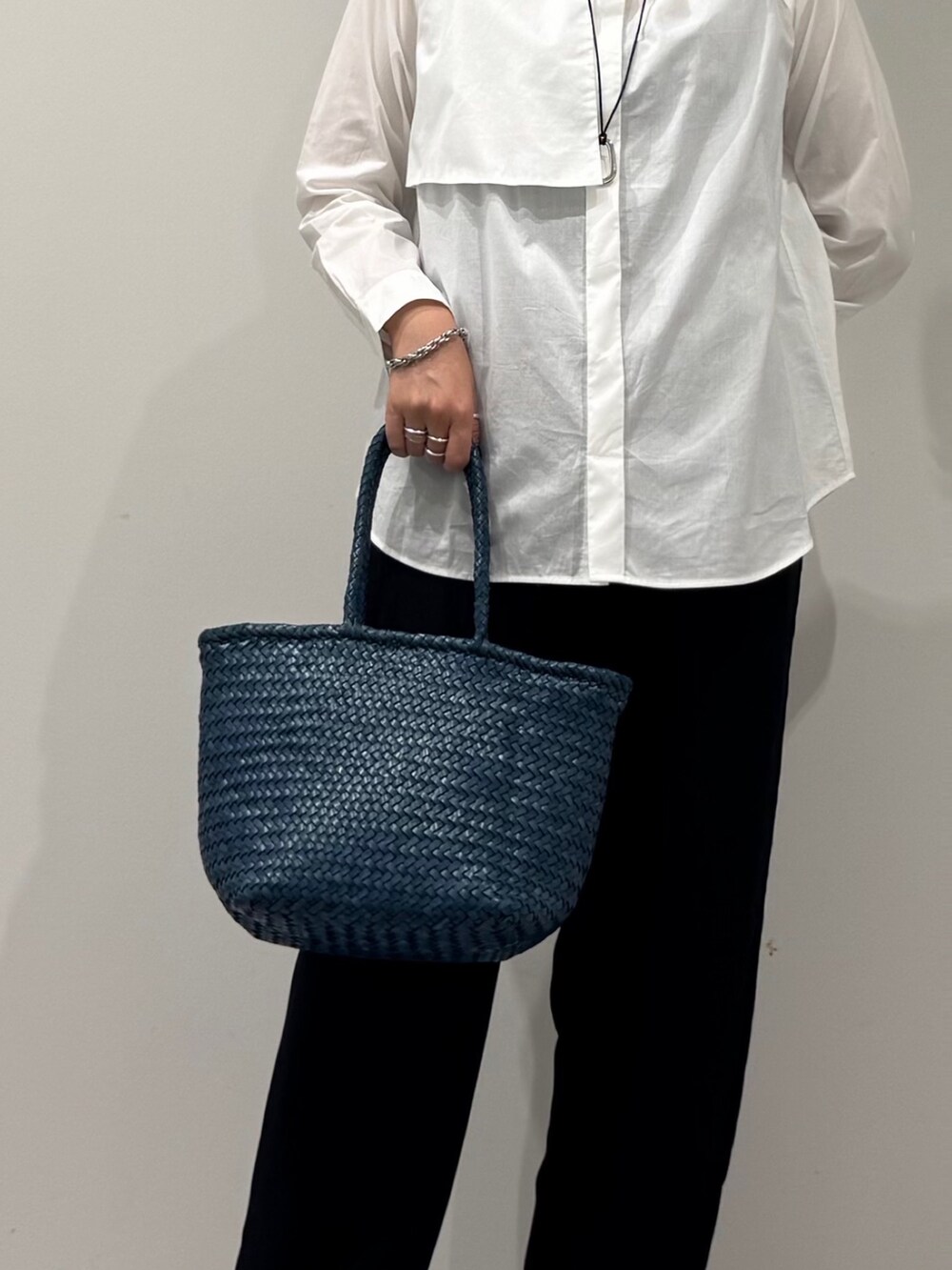 ブルー系のトートバッグ、ブラック系のその他パンツ、ホワイト系のシャツ/ブラウスを着用したレディースの秋コーディネートの7枚目の写真