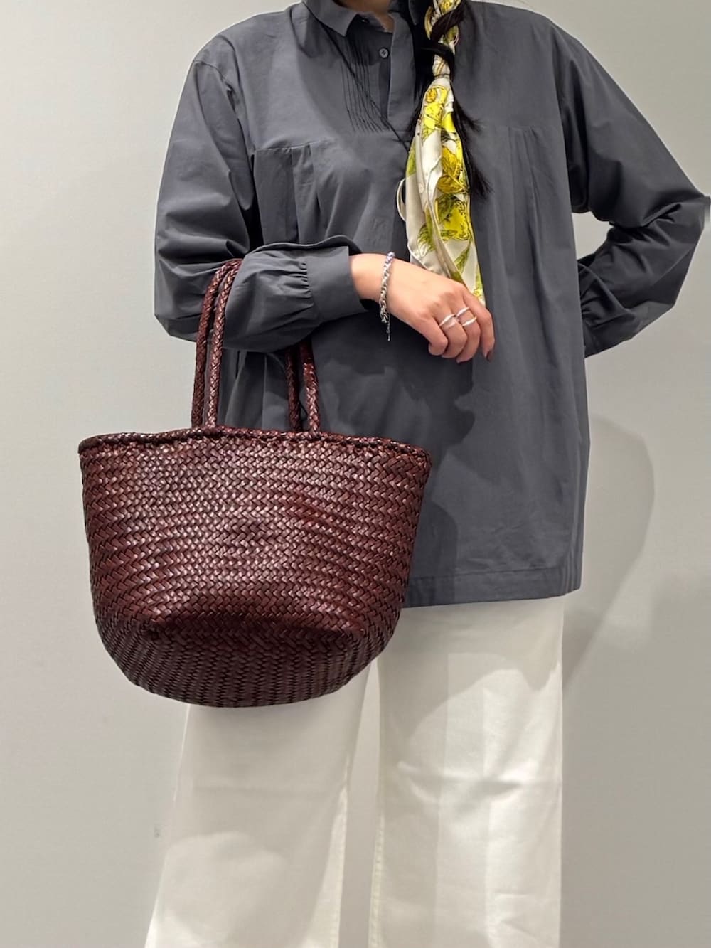 ブラウン系のトートバッグ、ホワイト系のデニムパンツ、ブラック系のローファーを着用したレディースの秋コーディネートの7枚目の写真