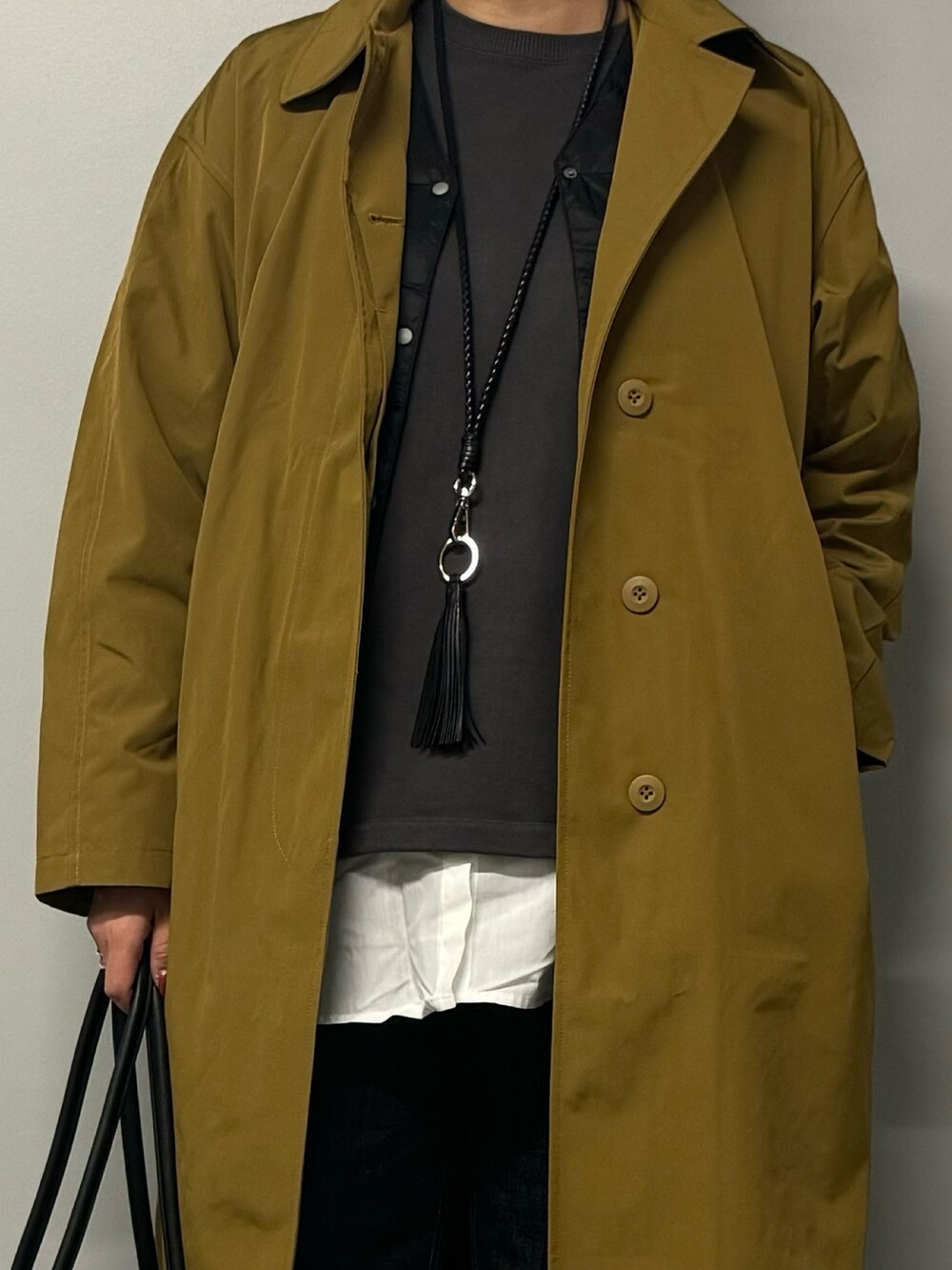 ベージュ系のダウンジャケット/コート、ブラック系のボストンバッグ、ブルー系のデニムパンツを着用したレディースの秋コーディネートの6枚目の写真