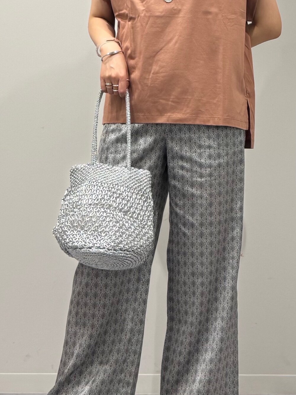 ピンク系のTシャツ/カットソー、シルバー系のかごバッグ、ベージュ系のその他パンツを着用したレディースの夏コーディネートの8枚目の写真