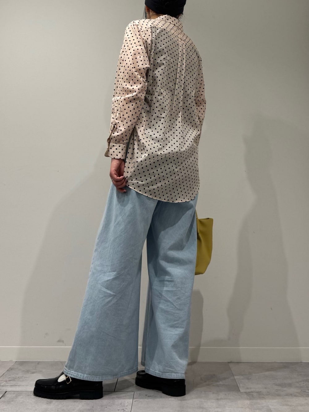 イエロー系のショルダーバッグ、ブルー系のデニムパンツ、ブラック系のローファーを着用したレディースの春コーディネートの4枚目の写真