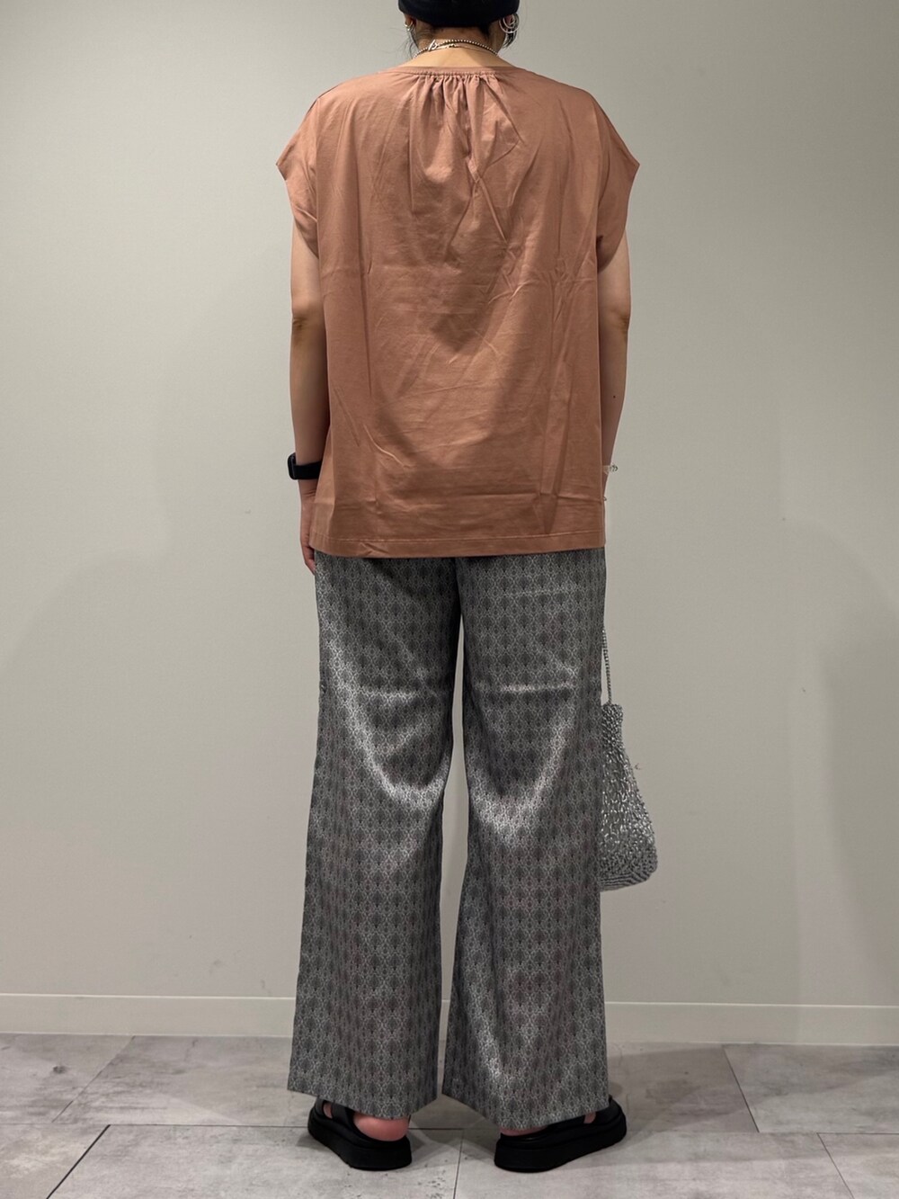 ピンク系のTシャツ/カットソー、シルバー系のかごバッグ、ベージュ系のその他パンツを着用したレディースの夏コーディネートの4枚目の写真