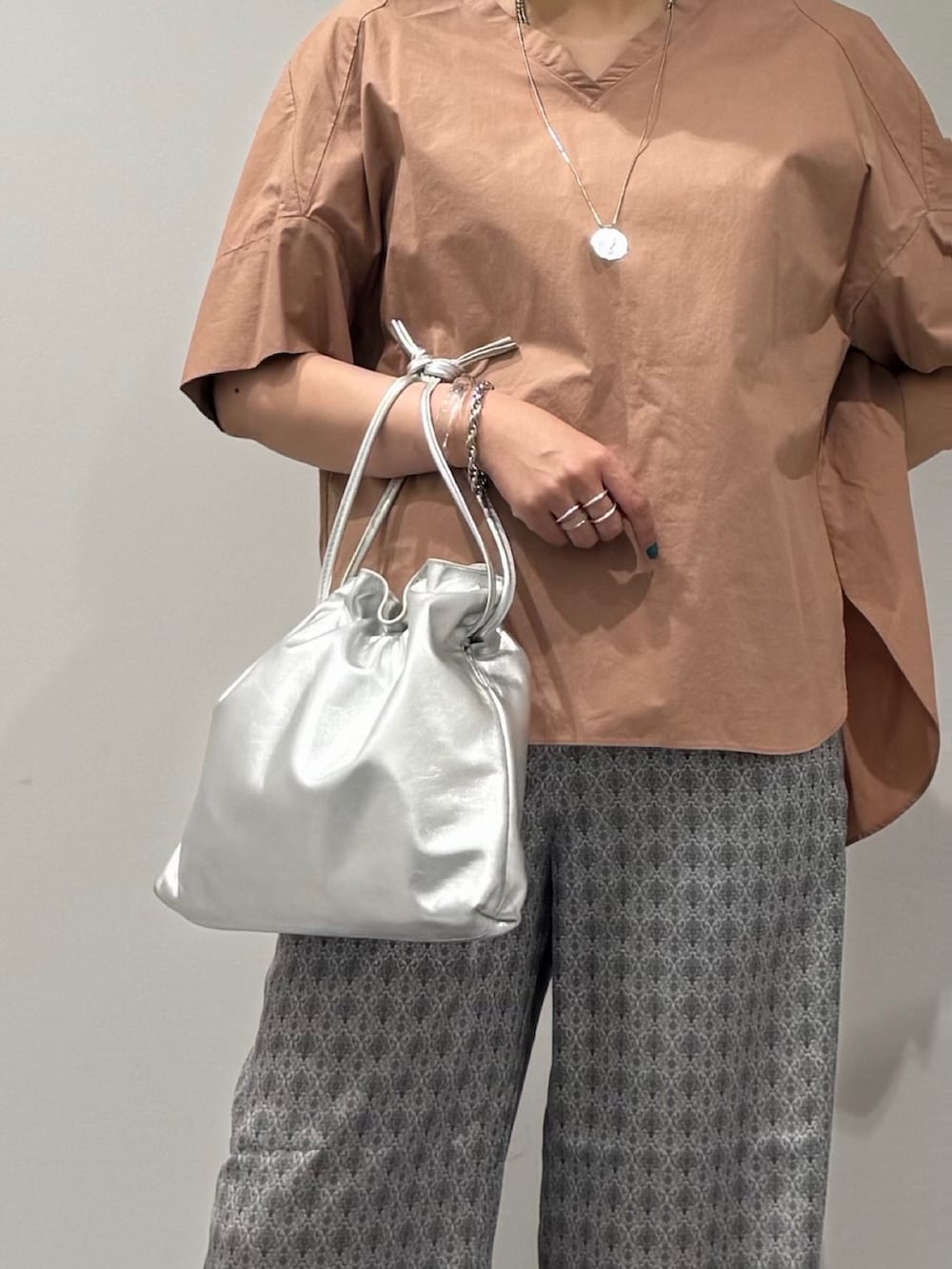 シルバー系のショルダーバッグ、ピンク系のシャツ/ブラウス、ベージュ系のその他パンツを着用したレディースの夏コーディネートの7枚目の写真