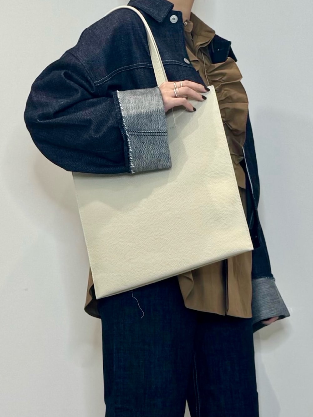 ブラウン系のシャツ/ブラウス、ブルー系のデニムジャケット、ブルー系のデニムパンツを着用したレディースの春コーディネートの7枚目の写真