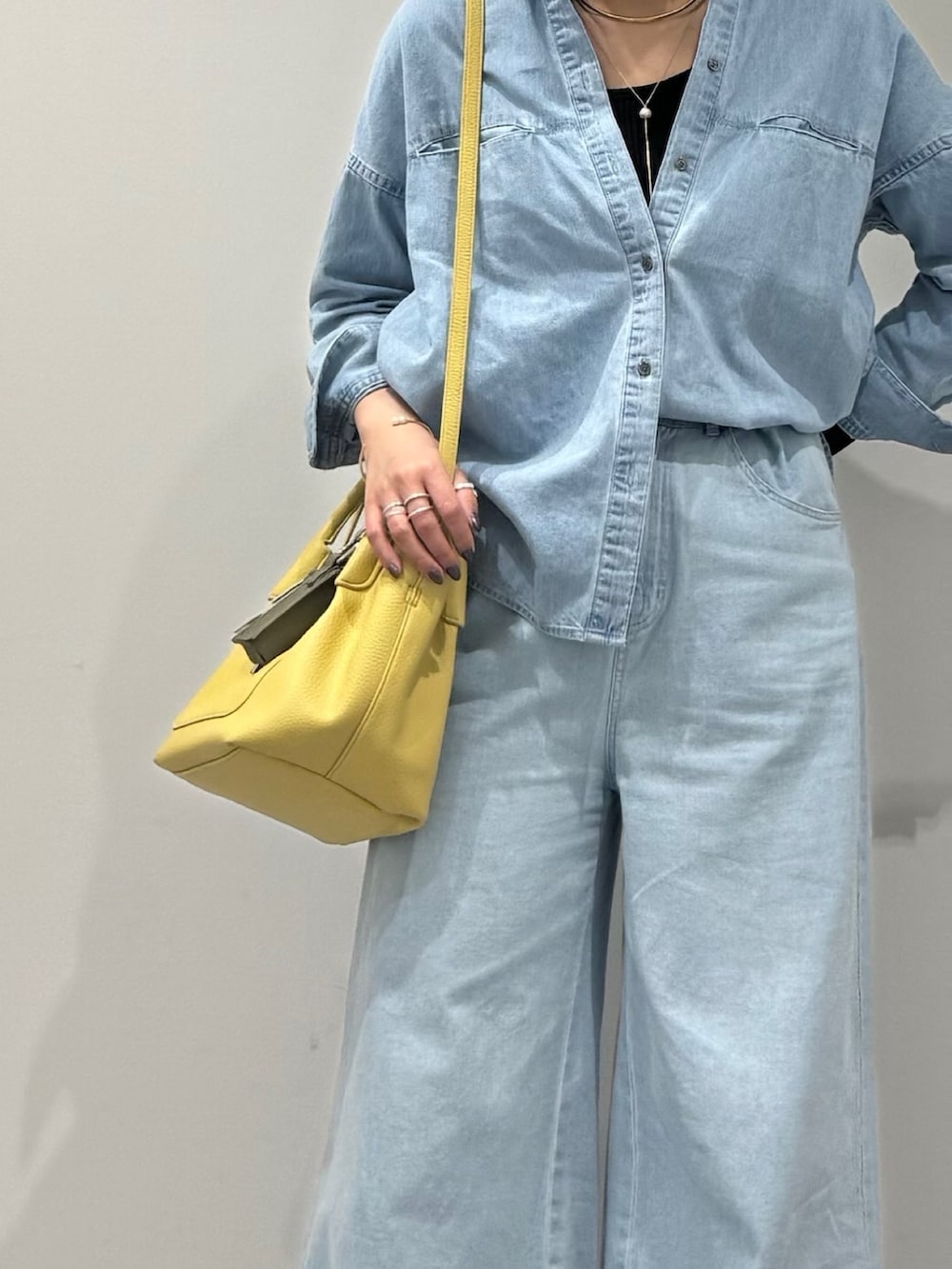 イエロー系のショルダーバッグ、ブルー系のデニムパンツ、ブラック系のローファーを着用したレディースの春コーディネートの10枚目の写真