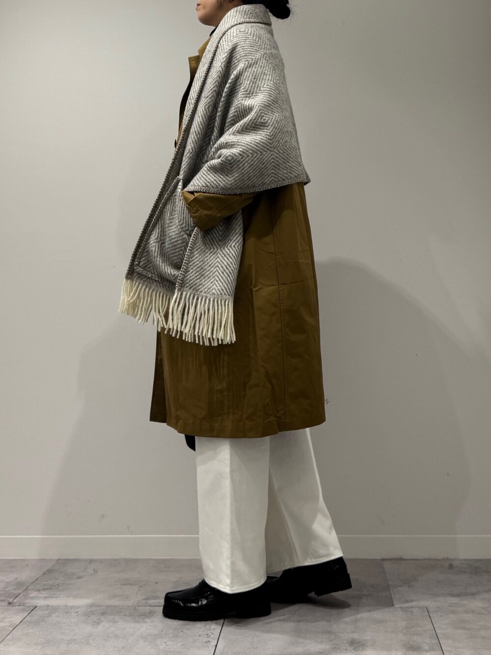 ブラック系のボストンバッグ、ベージュ系のダウンジャケット/コート、ホワイト系のデニムパンツを着用したレディースの冬コーディネートの5枚目の写真