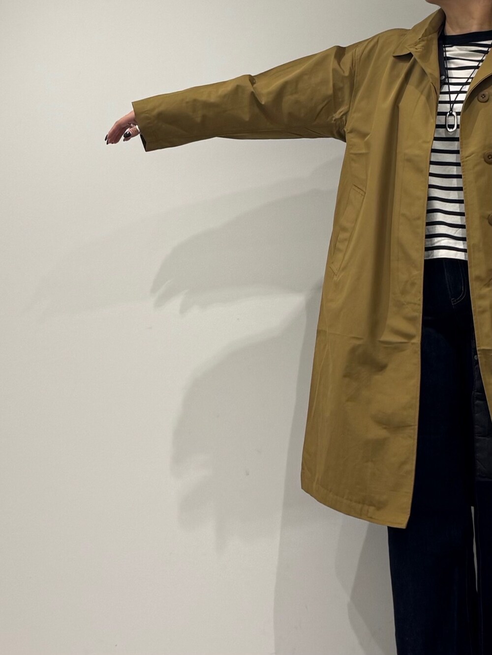 ブラック系のボストンバッグ、ベージュ系のダウンジャケット/コート、ブルー系のデニムパンツを着用したレディースの冬コーディネートの7枚目の写真