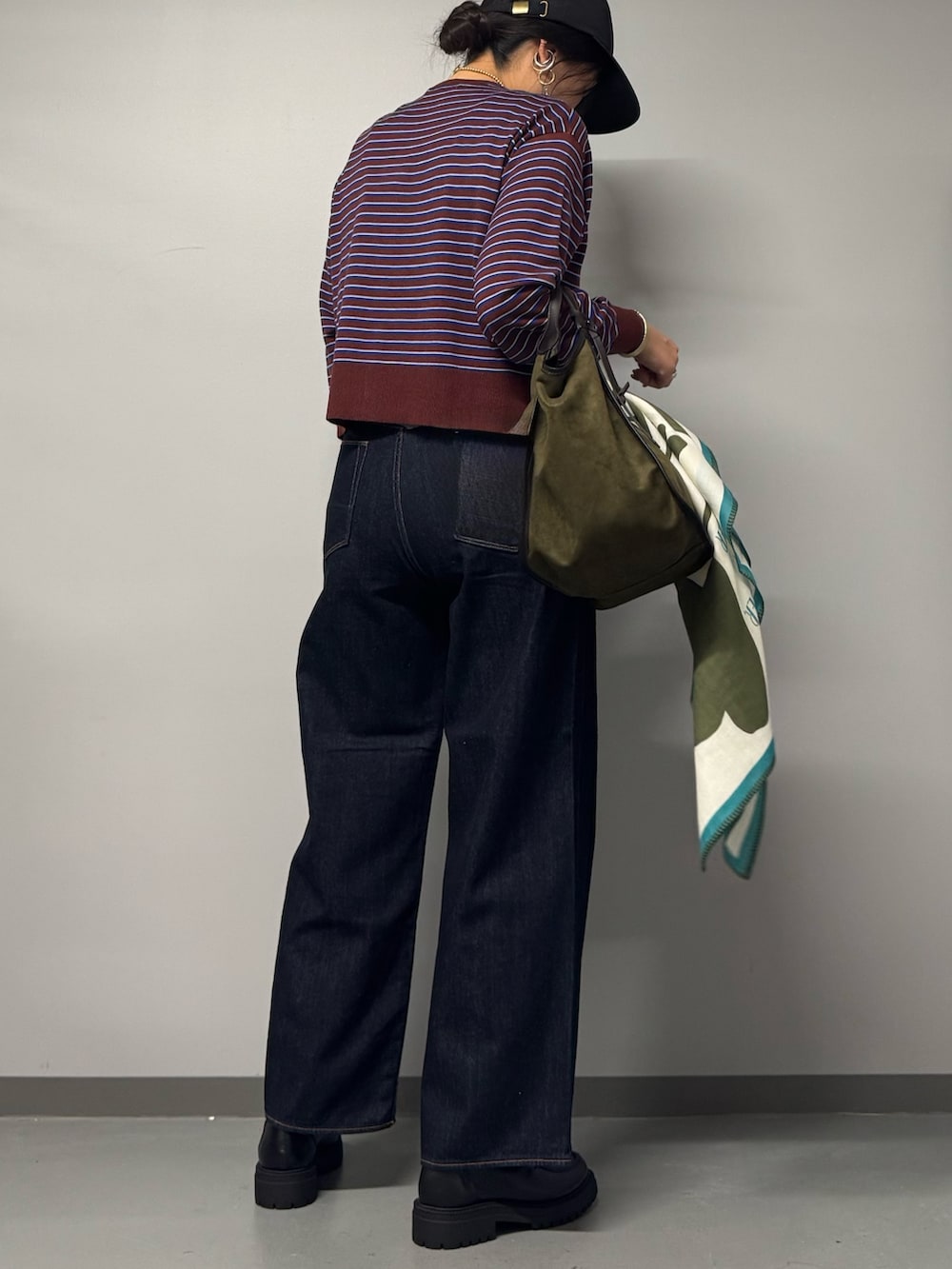 ブラック系のパンプス、ブルー系のデニムパンツ、レッド系のカーディガン/ボレロを着用したレディースの秋コーディネートの3枚目の写真