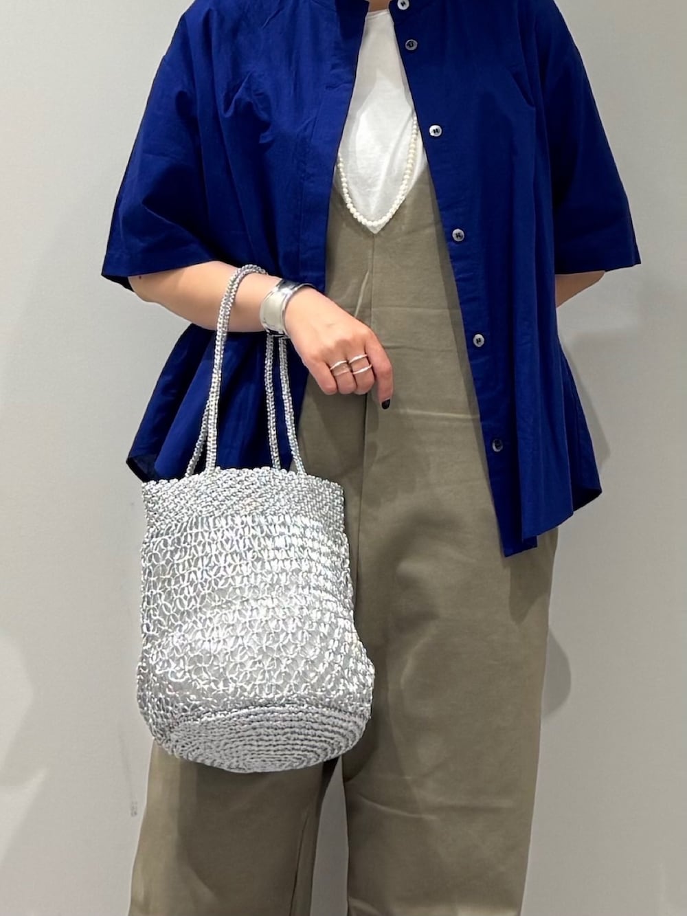 シルバー系のかごバッグ、グリーン系のサロペット/オーバーオール、ブルー系のシャツ/ブラウスを着用したレディースの夏コーディネートの6枚目の写真