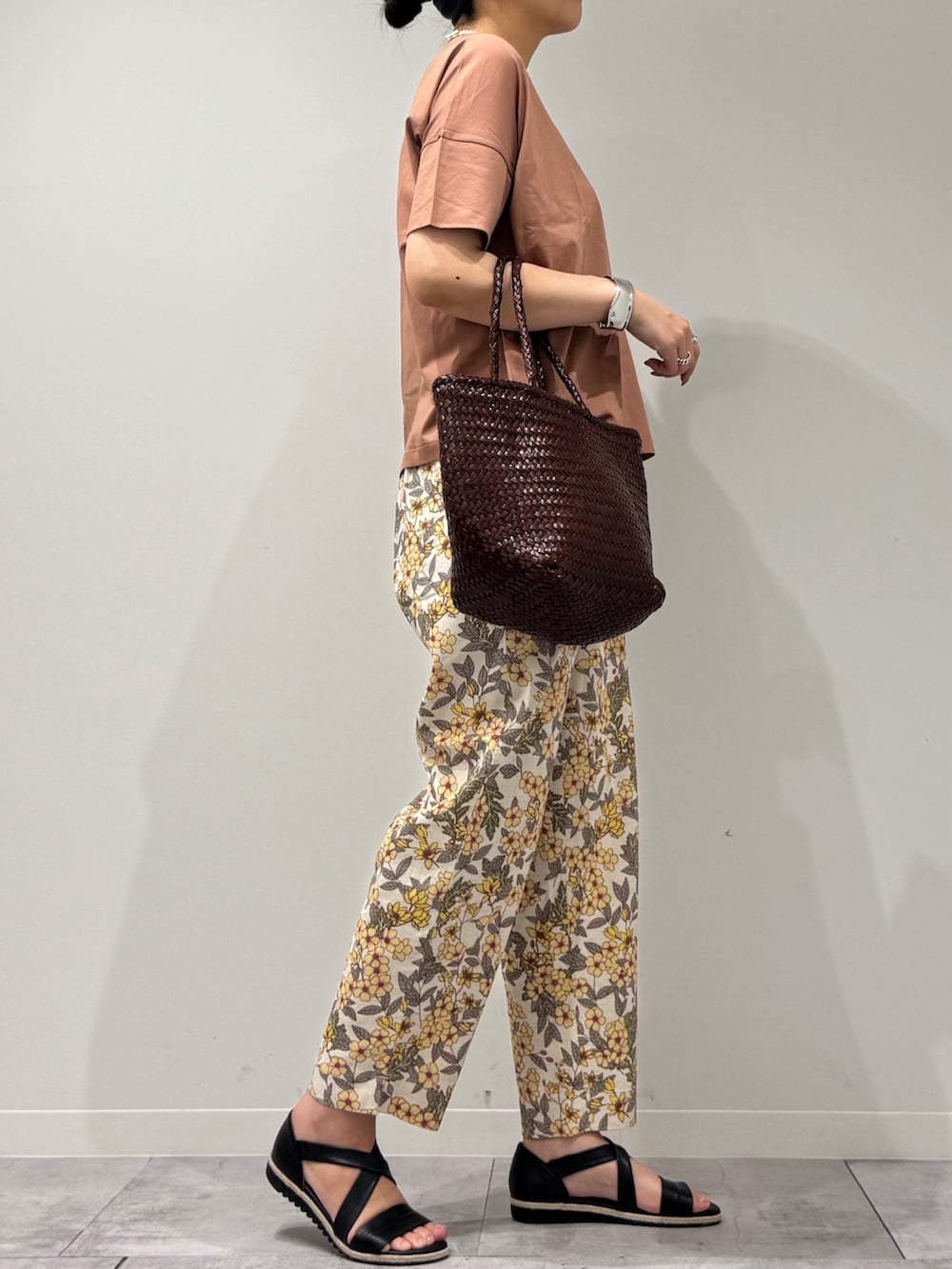 ブラウン系のトートバッグ、イエロー系のその他パンツ、ブラック系のサンダルを着用したレディースの春コーディネートの2枚目の写真