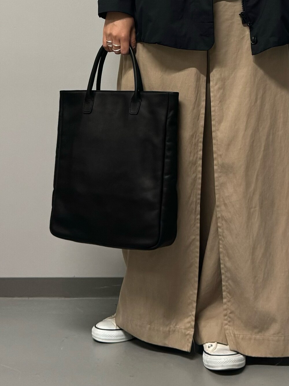 ブラック系のトートバッグ、ブラック系のブルゾン、ブラック系のTシャツ/カットソーを着用したレディースの秋コーディネートの8枚目の写真