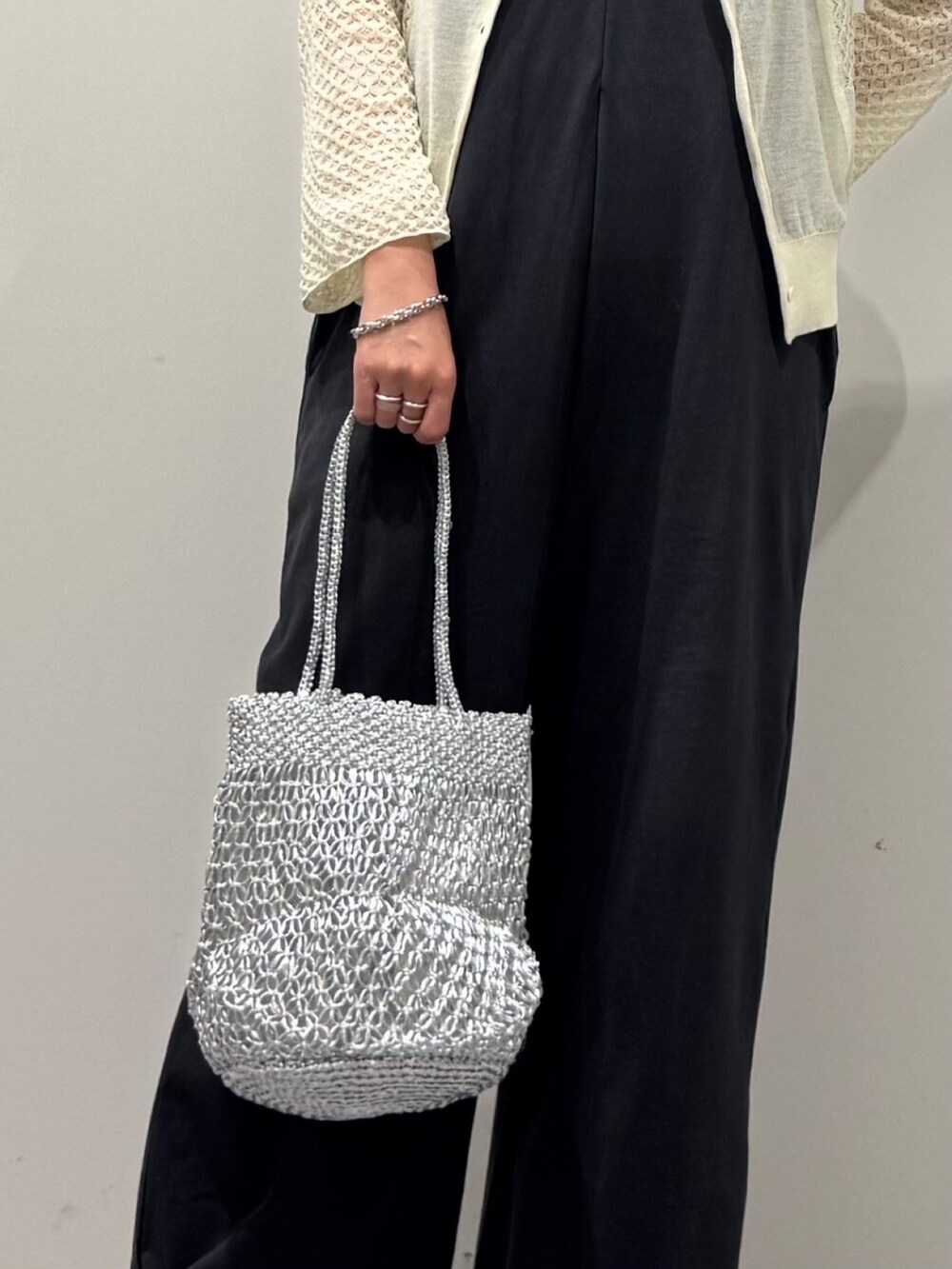 シルバー系のかごバッグ、グレー系のサロペット/オーバーオール、ブラック系のサンダルを着用したレディースの秋コーディネートの6枚目の写真