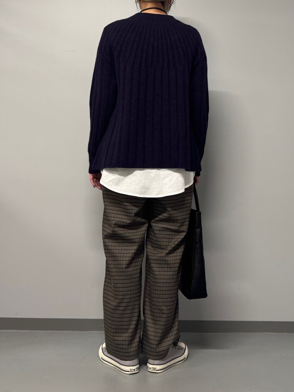 ブルー系のニット/セーター、ブラック系のトートバッグ、ブラウン系のその他パンツを着用したレディースの冬コーディネートの2枚目の写真