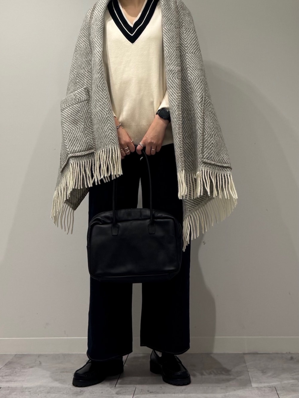 ブラック系のボストンバッグ、ブルー系のデニムパンツ、ブラック系のローファーを着用したレディースの冬コーディネートの6枚目の写真