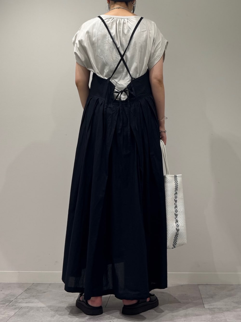 ブラック系のワンピース、ホワイト系のかごバッグ、ブラック系のサンダルを着用したレディースの夏コーディネートの3枚目の写真