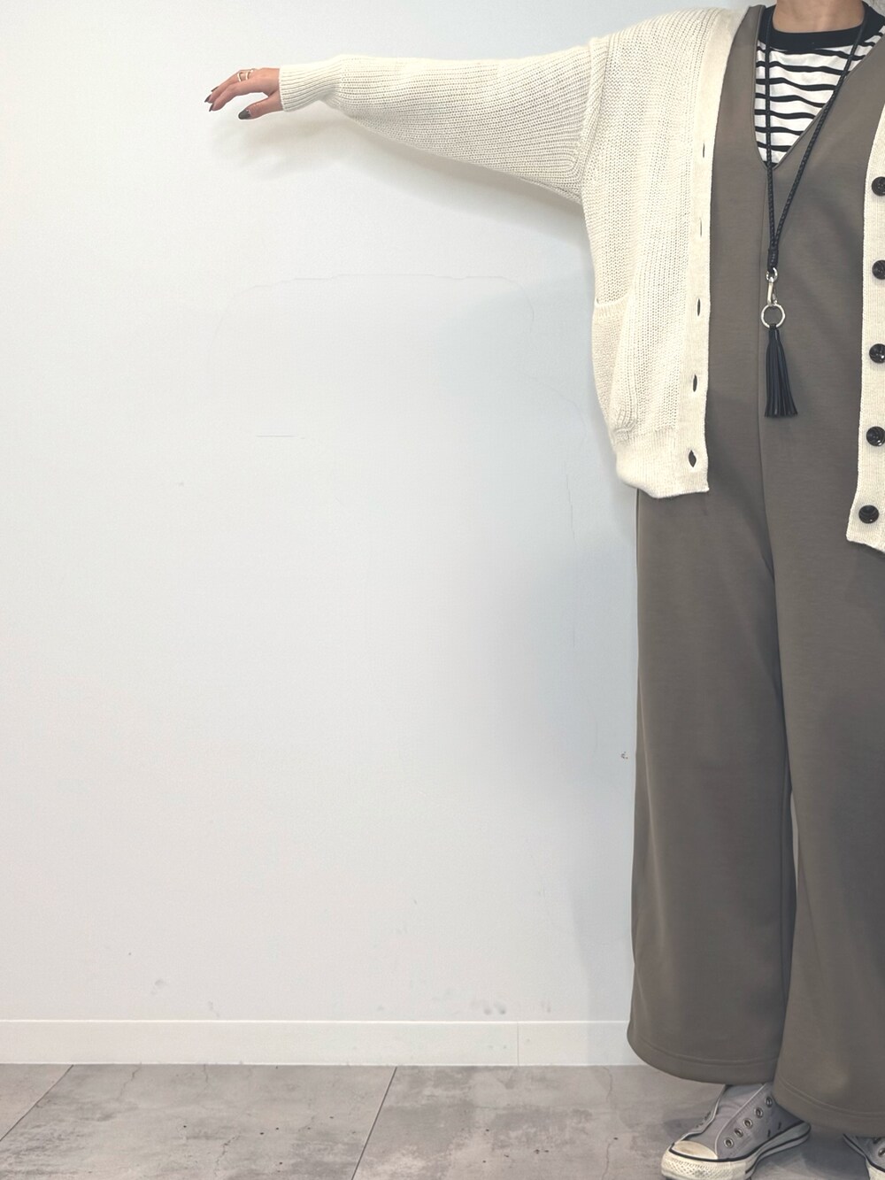 ブラック系のトートバッグ、ブラウン系のサロペット/オーバーオール、ホワイト系のカーディガン/ボレロを着用したレディースの冬コーディネートの7枚目の写真