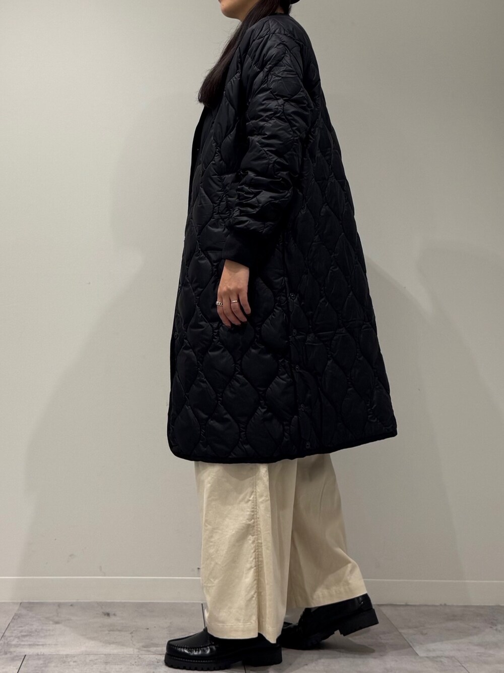 イエロー系のボストンバッグ、ブラウン系のベスト、ホワイト系のその他パンツを着用したレディースの秋コーディネートの5枚目の写真