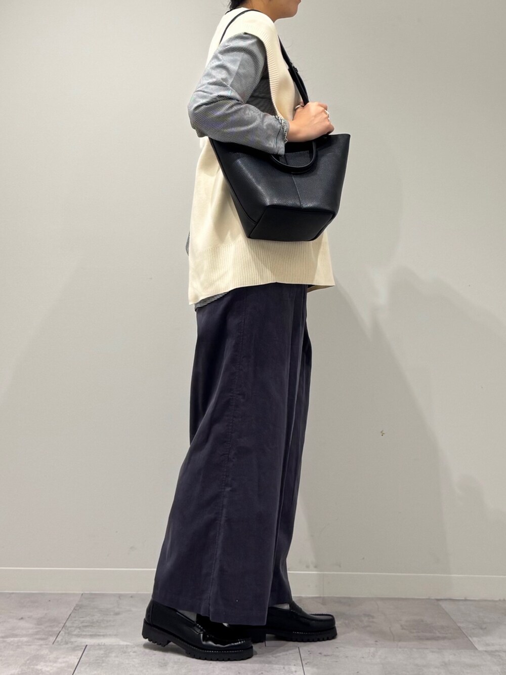 ブラック系のトートバッグ、グレー系のその他パンツ、ブラック系のローファーを着用したレディースの冬コーディネートの2枚目の写真