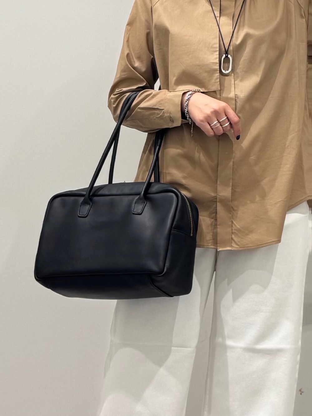 ベージュ系のシャツ/ブラウス、ホワイト系のデニムパンツ、ブラック系のボストンバッグを着用したレディースの秋コーディネートの9枚目の写真