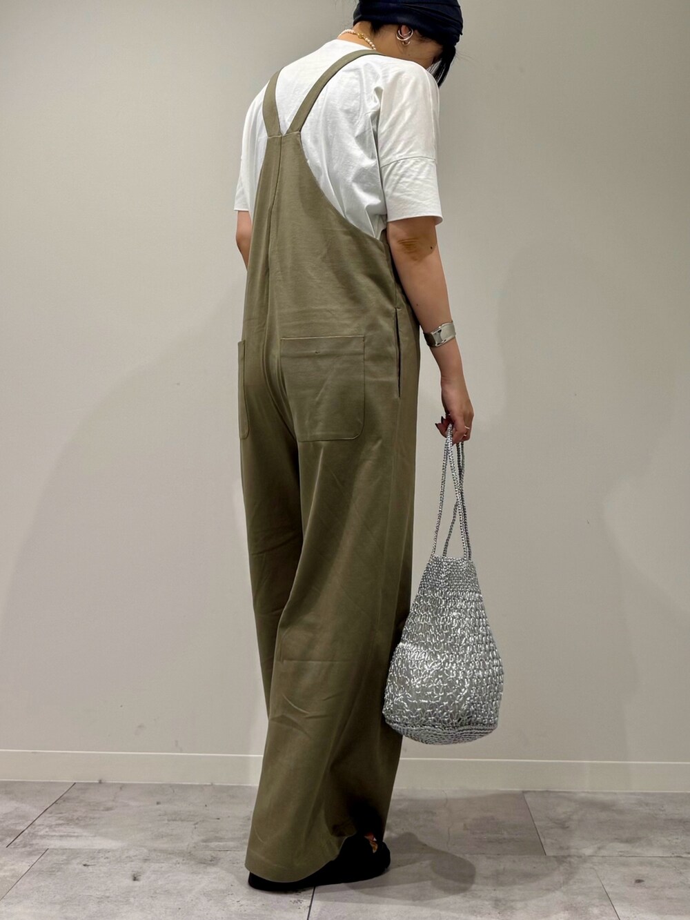 シルバー系のかごバッグ、ブラック系のサンダル、ホワイト系のTシャツ/カットソーを着用したレディースの夏コーディネートの3枚目の写真