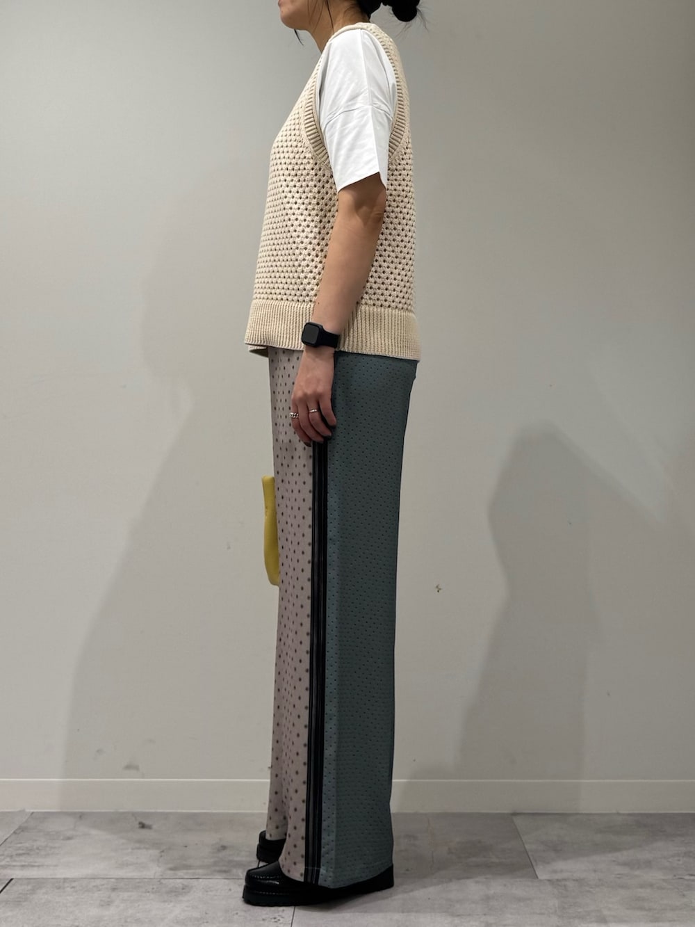 イエロー系のショルダーバッグ、ベージュ系のその他パンツ、ブラック系のローファーを着用したレディースの春コーディネートの5枚目の写真