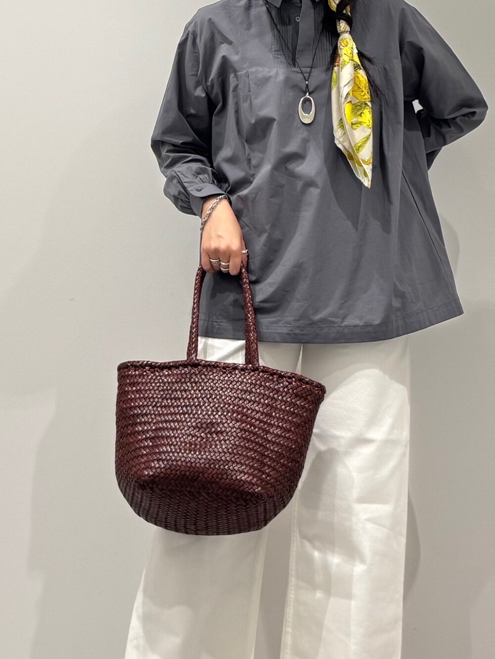 ブラウン系のトートバッグ、ホワイト系のデニムパンツ、ブラック系のローファーを着用したレディースの秋コーディネートの9枚目の写真