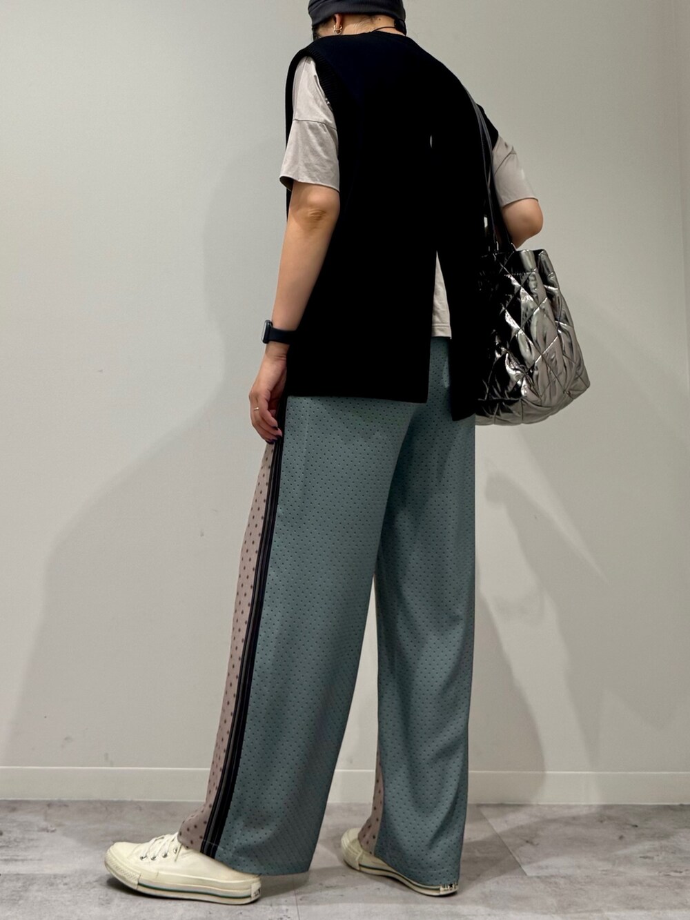 シルバー系のトートバッグ、ベージュ系のその他パンツ、ブラック系のベストを着用したレディースの秋コーディネートの4枚目の写真